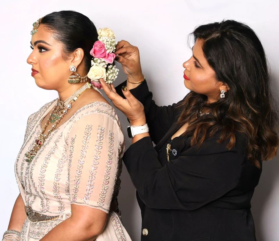Amulya arranging flowers in a bride’s braided updo