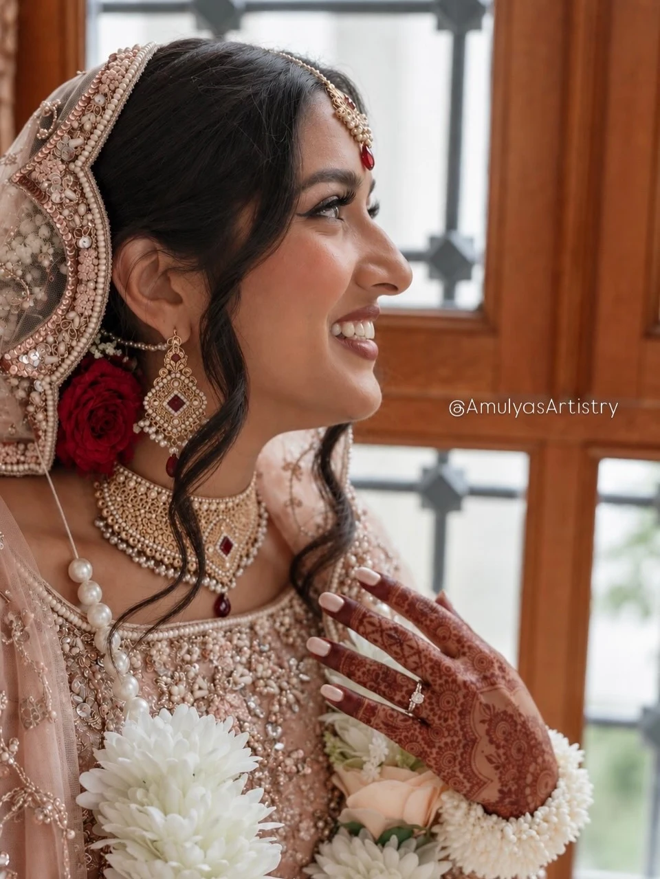 Bridal makeup with softly defined eyes, a blush dupatta and pearl jewelry