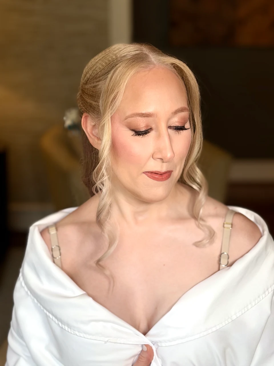 Blonde bridal preparation portrait with eyes lowered to show soft shimmering eye makeup