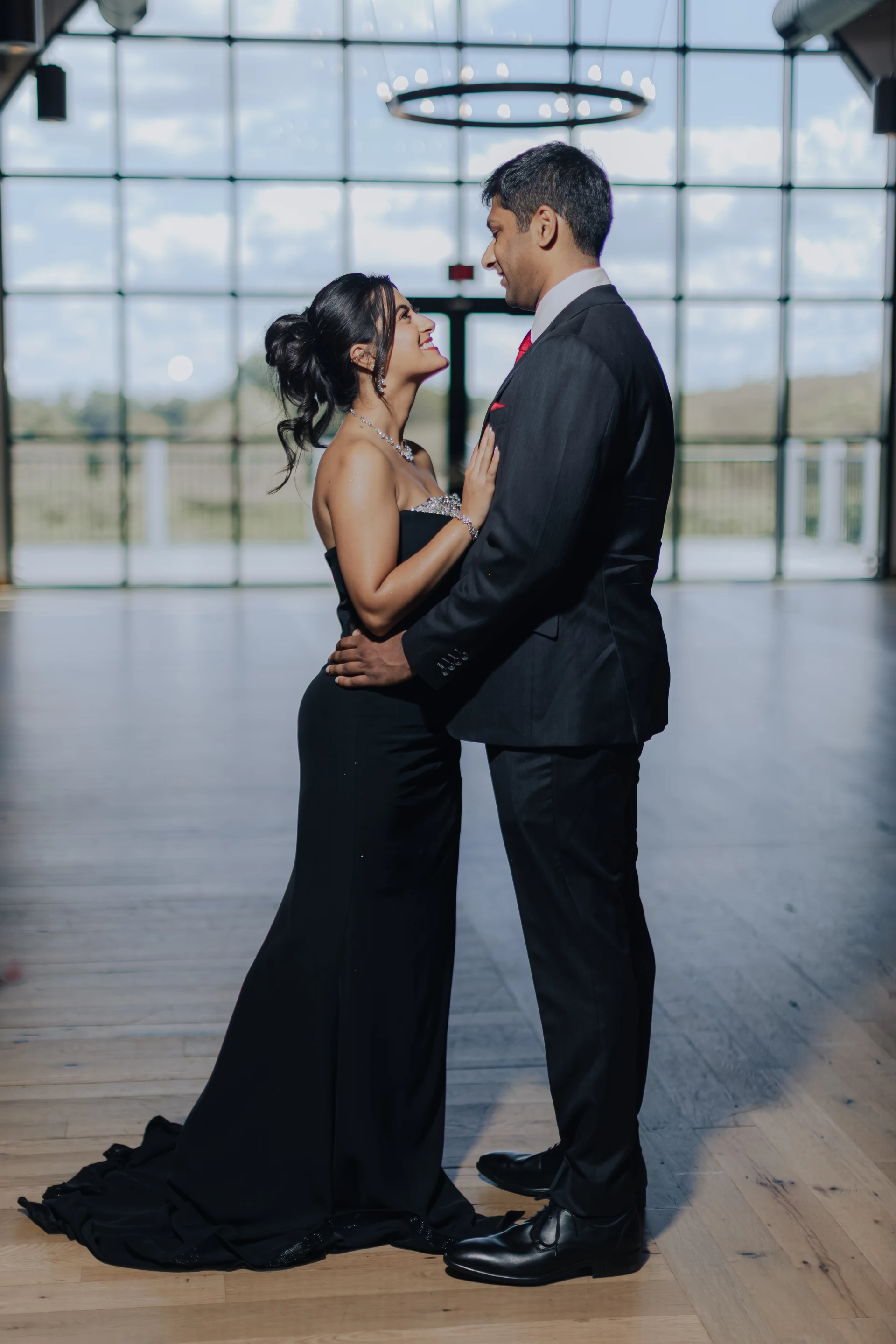 Couple in formal evening wear beside an arched window