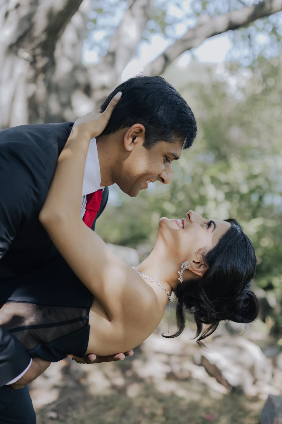 Outdoor couple portrait showing a swept-up hairstyle and evening makeup