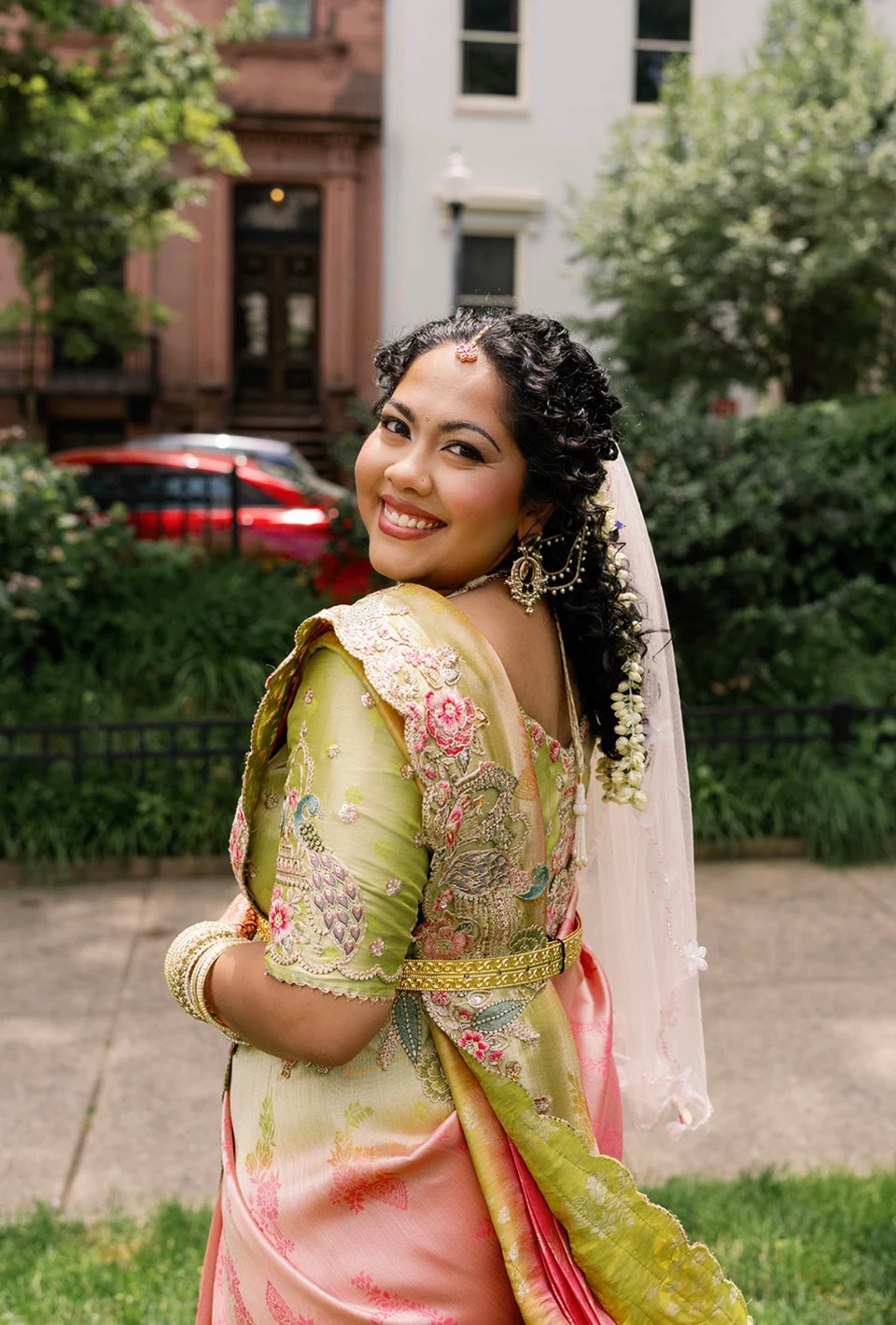 Bride looking over her shoulder with jasmine flowers adorning her long braid