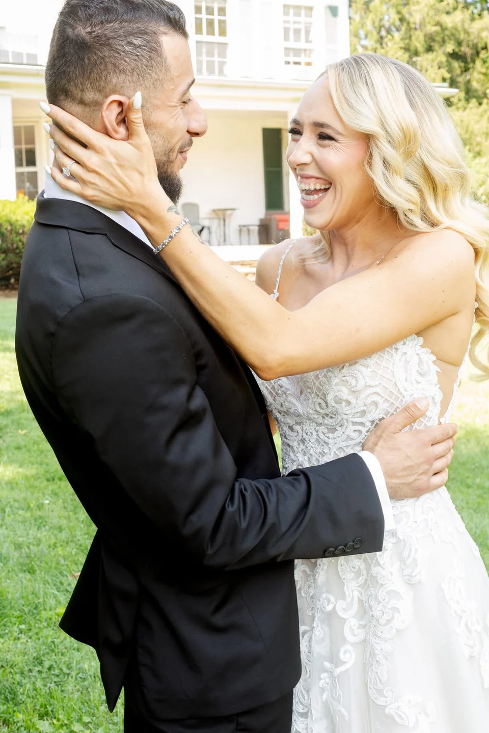 Bride with softly waved hair smiling at her groom during their first look